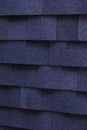 A dark blue architectural asphalt roofing shingles background. A close-up of a dimensional asphalt roofing shingles