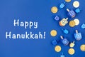 Dark blue background with dreidels and chocolate coins and Happy Hanukkah wording. Hanukkah and judaic holiday concept. Royalty Free Stock Photo