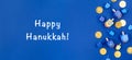 Dark blue background with dreidels and chocolate coins and Happy Hanukkah wording. Hanukkah and judaic holiday concept. Royalty Free Stock Photo