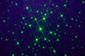 On a dark blue background in fine grain, a pattern of green stars and green dots