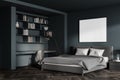 Dark blue bedroom interior with bed and linens, bookshelf and mockup poster Royalty Free Stock Photo