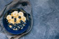 Dark blue bowl of oatmeal porridge with banana and blueberry on vintage table top view in flat lay style. Hot breakfast Royalty Free Stock Photo