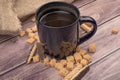 Dark blue ceramic mug with tea, cookie sticks with chocolate and white icing and pieces of brown cane sugar on a wooden background Royalty Free Stock Photo