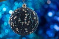 Dark blue Christmas decoration globe with small flakes pattern and blue shiny background