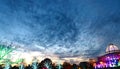 Cloud-Studded Sky at Dusk With Christmas Lights Below Royalty Free Stock Photo