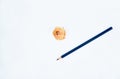 A dark blue colored wood pencil crayon placed beside some pencil shavings Royalty Free Stock Photo