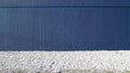 Dark blue concrete wall with white small pebbles road in front. Background for copy text