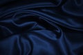 Dark blue elegant background. Crumpled satin texture background. The surface of a dark blue shiny fabric with nice folds.