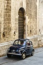 Dark blue Fiat 500 in front of an old building in the Italian city Gubbio, Italy