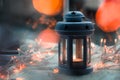 Dark blue and gray candle lantern with blurred orange Christmas lights and bokeh Royalty Free Stock Photo