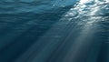 Dark blue ocean surface seen from underwater. Abstract waves underwater and rays of sunlight shining through Royalty Free Stock Photo