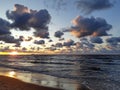 Dark blue and orange clouds in the sunset over the wavy sea Royalty Free Stock Photo