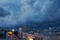 A dark blue overcast sky above a residential street with houses