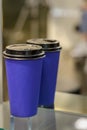 Dark blue paper disposable glass for hot drinks stands on a glass shelf Royalty Free Stock Photo