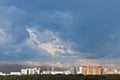 Dark blue rainy clouds in sunset sky over city Royalty Free Stock Photo