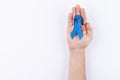 Dark blue ribbon over palm. White background