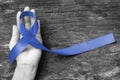 Dark blue ribbon symbolic for colon - colorectal cancer and Acute Respiratory Distress Syndrome ARDS awareness on hand