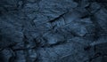 Dark blue rock texture. Toned rough mountain surface with cracks. Close-up. Stone background. Royalty Free Stock Photo
