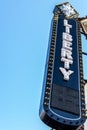 Dark blue sign with white letters/lettering LIBERTY and bulbs to illuminate at night.