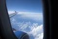 Dark Blue Sky and Clouds and an Airplane Wing and Engine Seen Through an Airplane Window Royalty Free Stock Photo