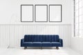 Dark blue sofa in a room with three posters Royalty Free Stock Photo