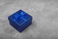 Dark blue square gift box with shiny satin bow Royalty Free Stock Photo