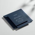 Dark blue square wedding invitation card and envelope on a light surface. The card Royalty Free Stock Photo