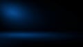 Dark blue studio background with spotlight and subtle floor illumination Royalty Free Stock Photo