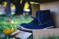 dark blue suede sneakers peeking out of a halfopen box