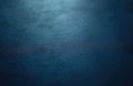 Dark blue surface with fine texture visible. Light creates subtle gradient across material. Abstract background offers rich, deep Royalty Free Stock Photo