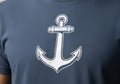 A dark blue T-shirt featuring a large white anchor graphic centered on the front. The anchor design Royalty Free Stock Photo