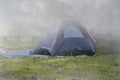 Dark blue tent for sleeping in thick morning fog Royalty Free Stock Photo