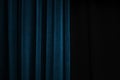 Dark blue velvet curtain on one side of a black theatre stage, event background concept with large copy space Royalty Free Stock Photo