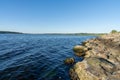 Dark blue water and forest shore with a rock jetty on the side on the Mariager Fjord in Denmark Royalty Free Stock Photo