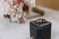 Dark blue wedding box with wedding rings inside on white marble stone. Wedding bouquet of dried flowers. Holiday concept Royalty Free Stock Photo