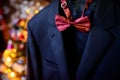 Dark blue wedding suit and wine-colored bow-tie on blurred background. Butterfly necktie on the man& x27;s costume. Close Royalty Free Stock Photo