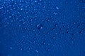 Dark blue wet glass background. Water drops on clear surface