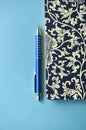 Dark blue and white floral notebook with blue pencils on white and blue background, detail Royalty Free Stock Photo