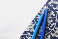 Dark blue and white floral notebook with blue pencils on white and blue background, detail Royalty Free Stock Photo