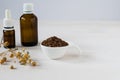 Dark bottles with flax oil, seeds in a spoon and a dry stalk of flax on a light wooden table. Omega-3