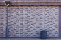 Dark brick wall pattern with masonry. Background texture modern stone wall with lamp post and street trash can Royalty Free Stock Photo