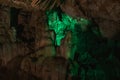 Dark bright green abstract background of stalactites, stalagmites and stalagnates in the Sfendoni cave, underground, horizontal