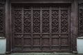 The dark brown ancient wooden door panel built in traditional Chinese architectural style and pattern Royalty Free Stock Photo