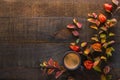 Dark brown clay cup with black coffee and branches of autumn leaves Spiraea Vanhouttei with Physalis on the old wooden table. To Royalty Free Stock Photo