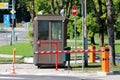 Dark brown metal security post with two CCTV security surveillance cameras on top surrounded with closed red and white barriers Royalty Free Stock Photo