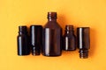 Dark brown phials on yellow background. Small empty bottles Royalty Free Stock Photo