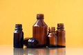 Dark brown phials on yellow background. Small empty bottles Royalty Free Stock Photo