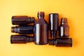 Dark brown phials on yellow background. Small empty bottles Royalty Free Stock Photo