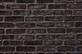 Dark brown rough brick wall close-up texture for background Royalty Free Stock Photo