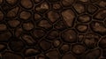 Dark brown wall made of stone and cement. Mosaic of rocks used as tiles. Toned dark sepia stone fence. Decorative texture from